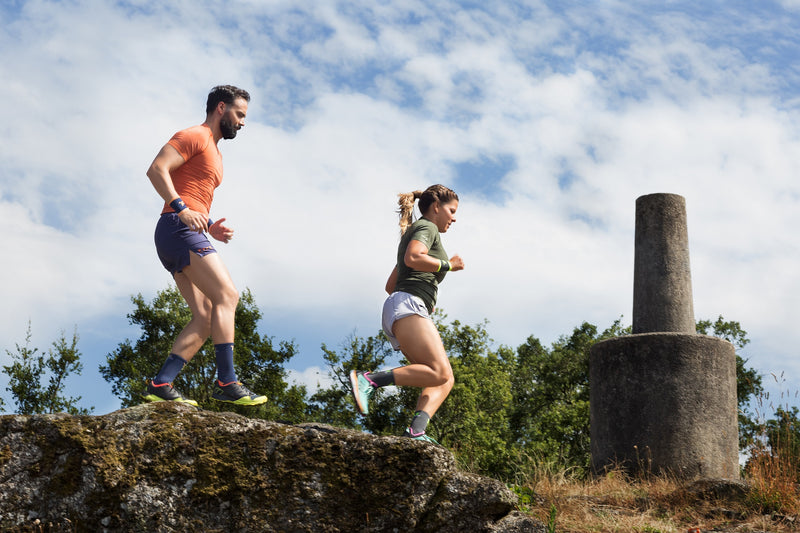 Hombre y mujer corriendo con su ropa de entrenamiento sin costuras.