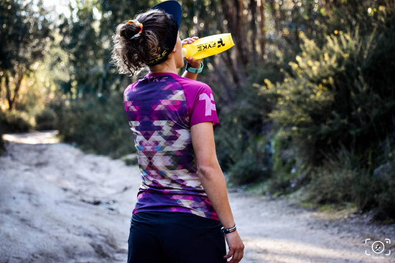 mujer bebiendo de un soft flask