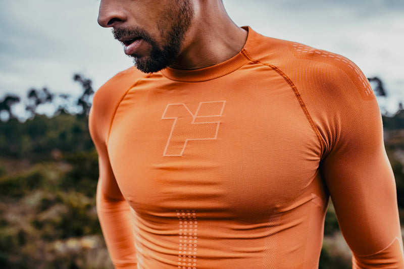 Homme portant une chemise orange à manches longues sans couture de Fyke