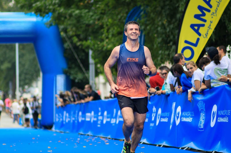 Homem a correr uma maratona com uma camisola Fyke sem mangas.